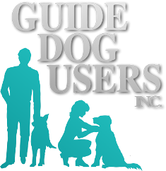 Guide Dog Users Inc. Logo. In this image is a man standing next to his dog and to his immediate right is a woman kneeling next to her dog. Immediately above them all are the words "Guide Dog Users Inc.